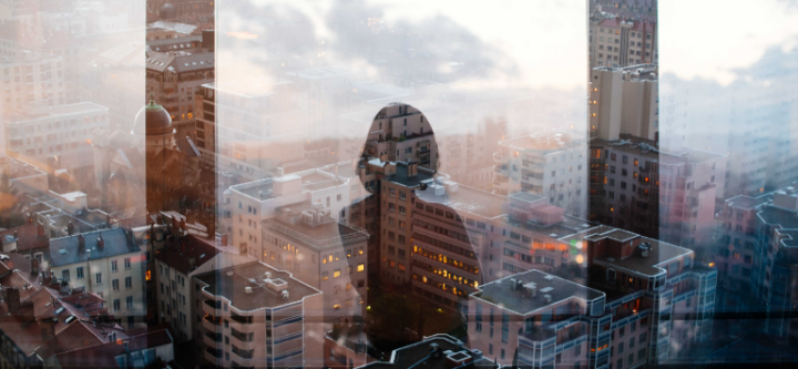image of person looking out window at buildings