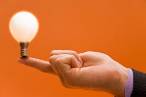 Image of a hand balancing a light bulb for innovation